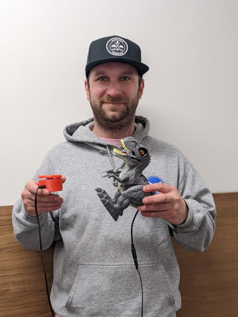 Chris from the movement centre holding assistive devices.