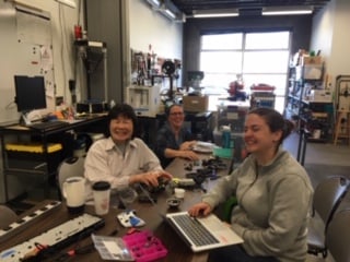 Three volunteers making assistive devices.