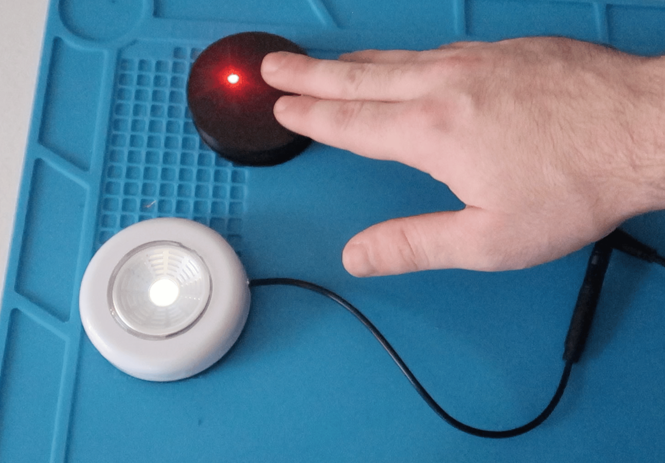 A person activates a light by using a Round Touch 60 Assistive Switch.