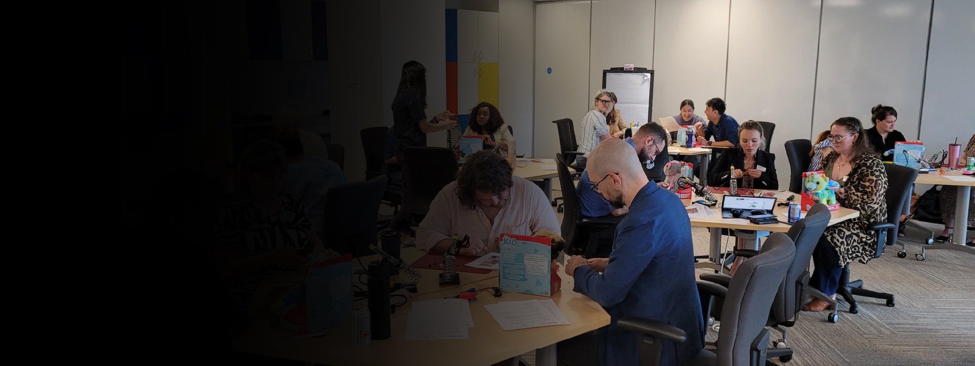 A group of makers in a large room adapting toys