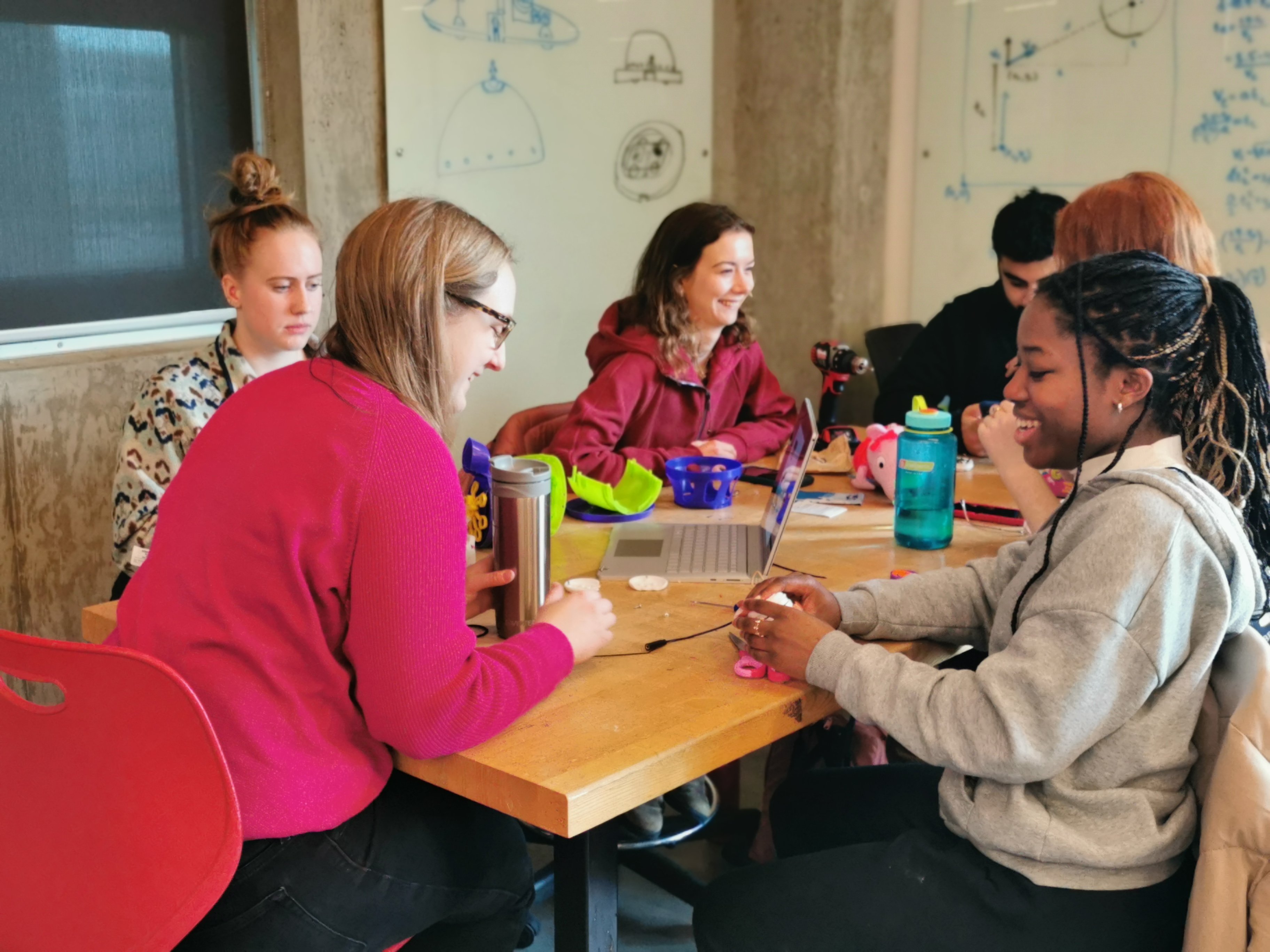 A group of university students at a table adapting a toy.