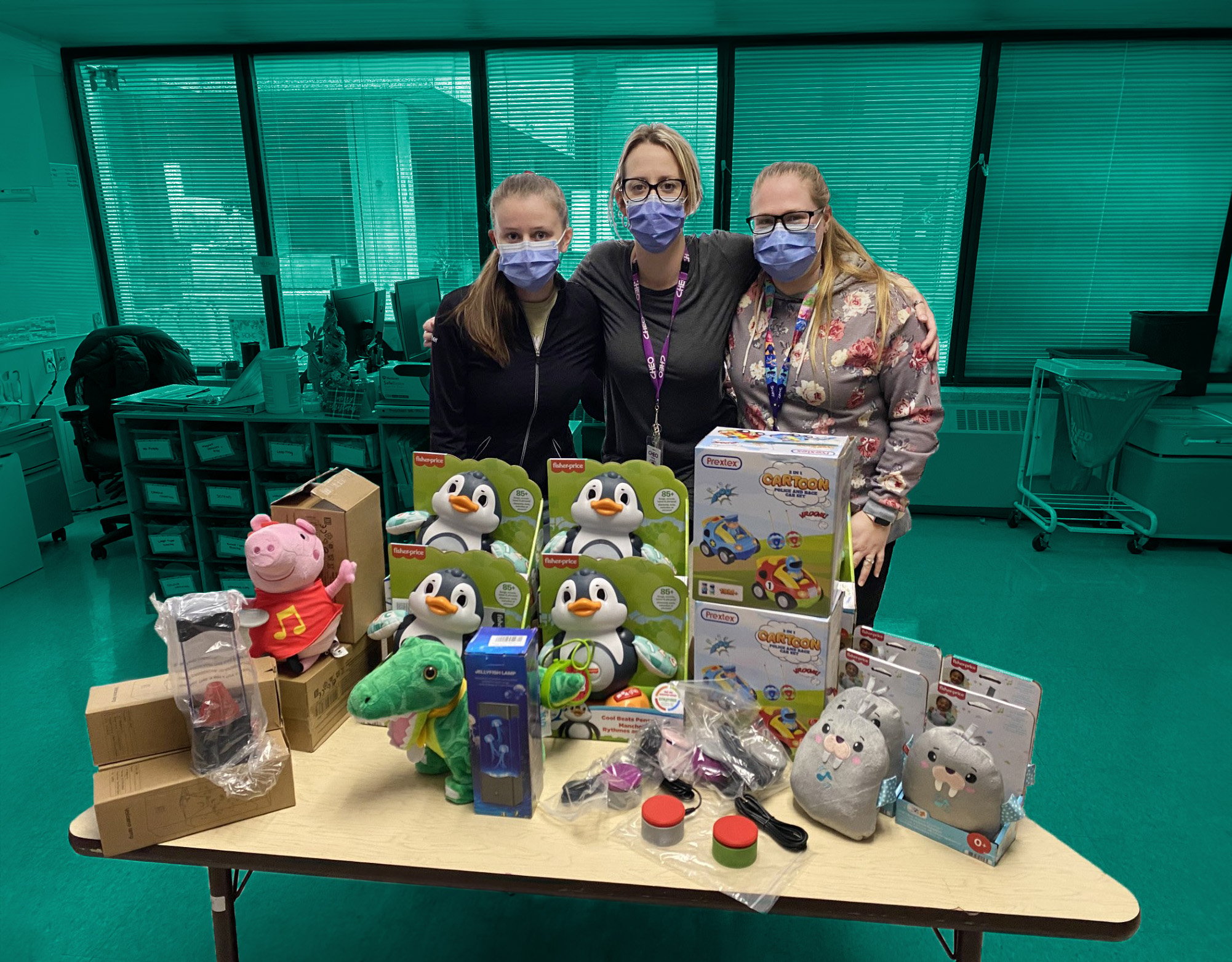 3 occupational therapist standing in front of a table with numerous adapted toys
