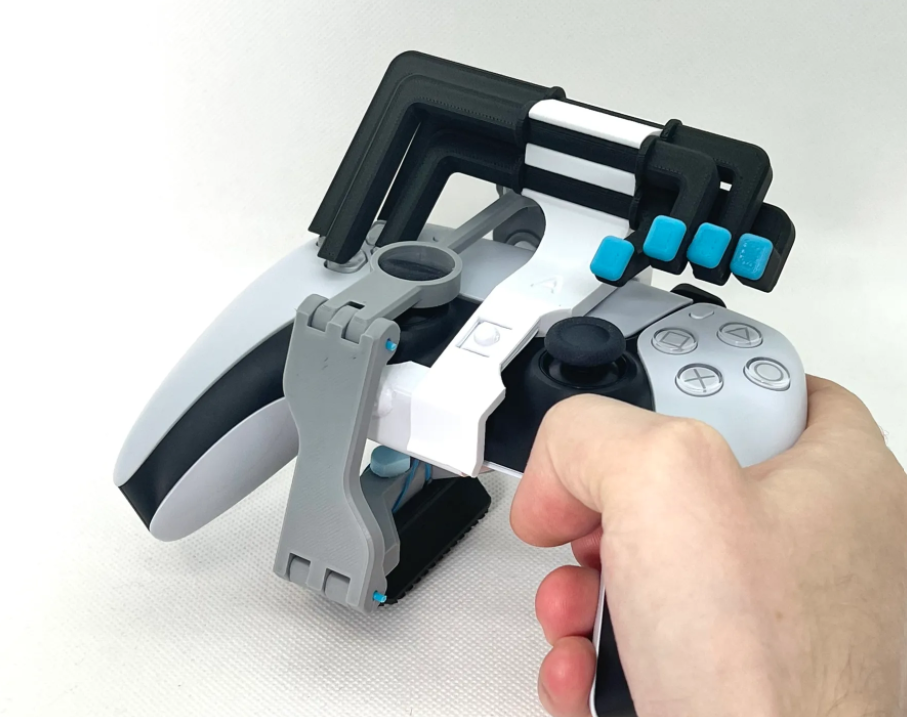 A right hand holding the PlayStation 5 dualsense controller with 3d printed button modifications attached.