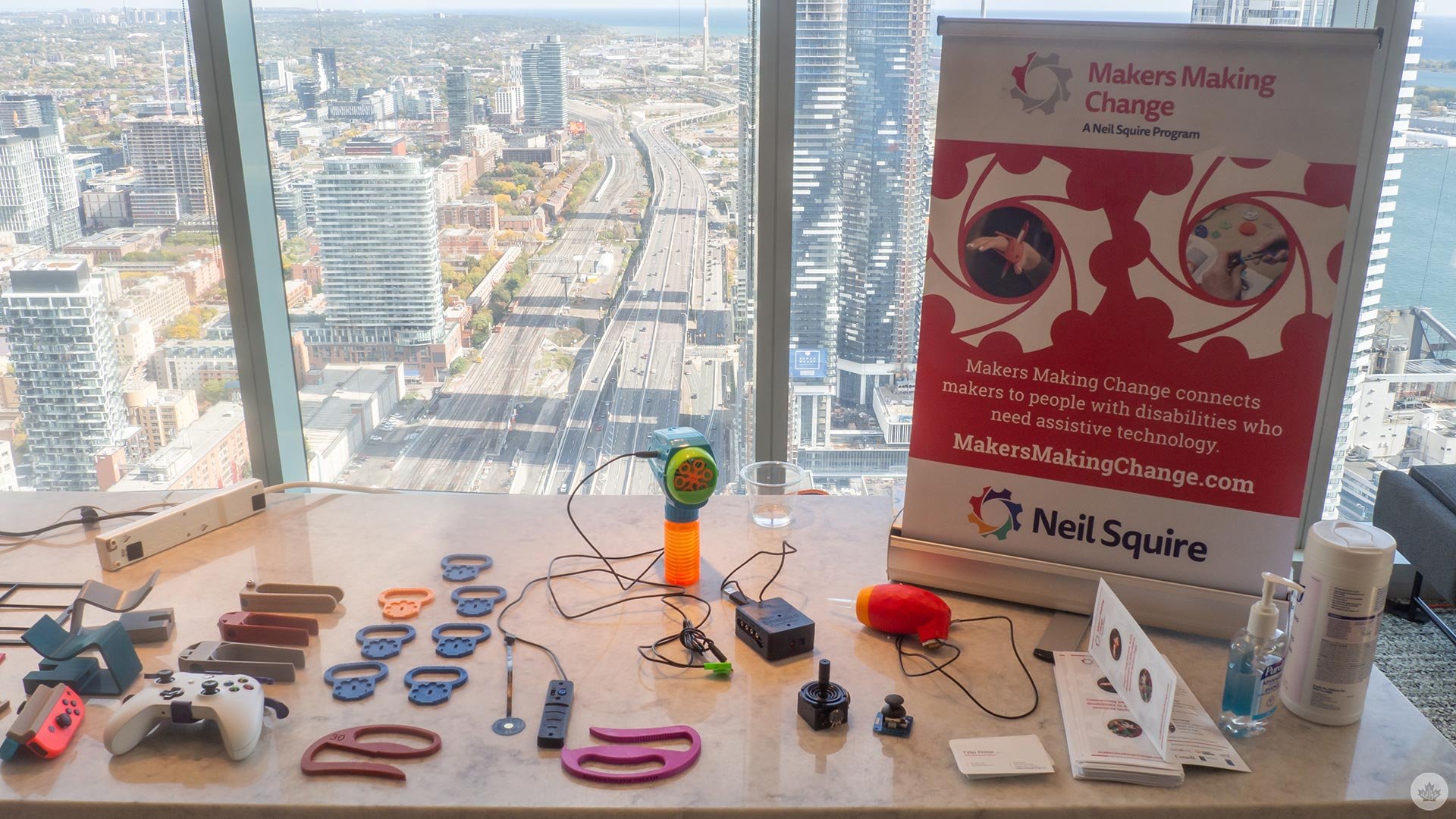An MMC banner and various 3d printed assistive devices displayed on a table