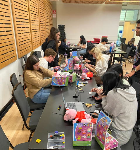 Students work at a table adapting Peppa Pig toys
