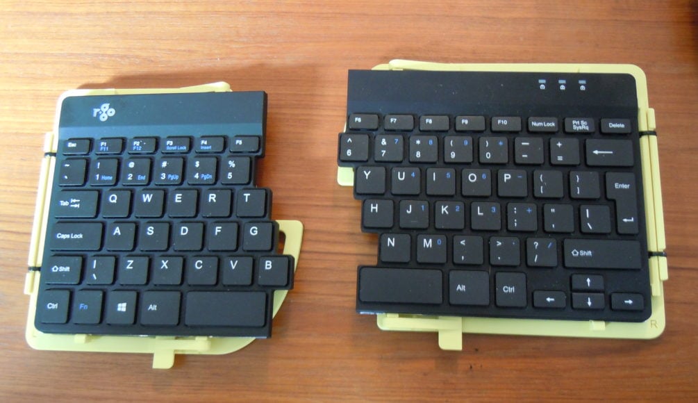 A yellow 3d printed tenting stand holding a separated r-go split keyboard.