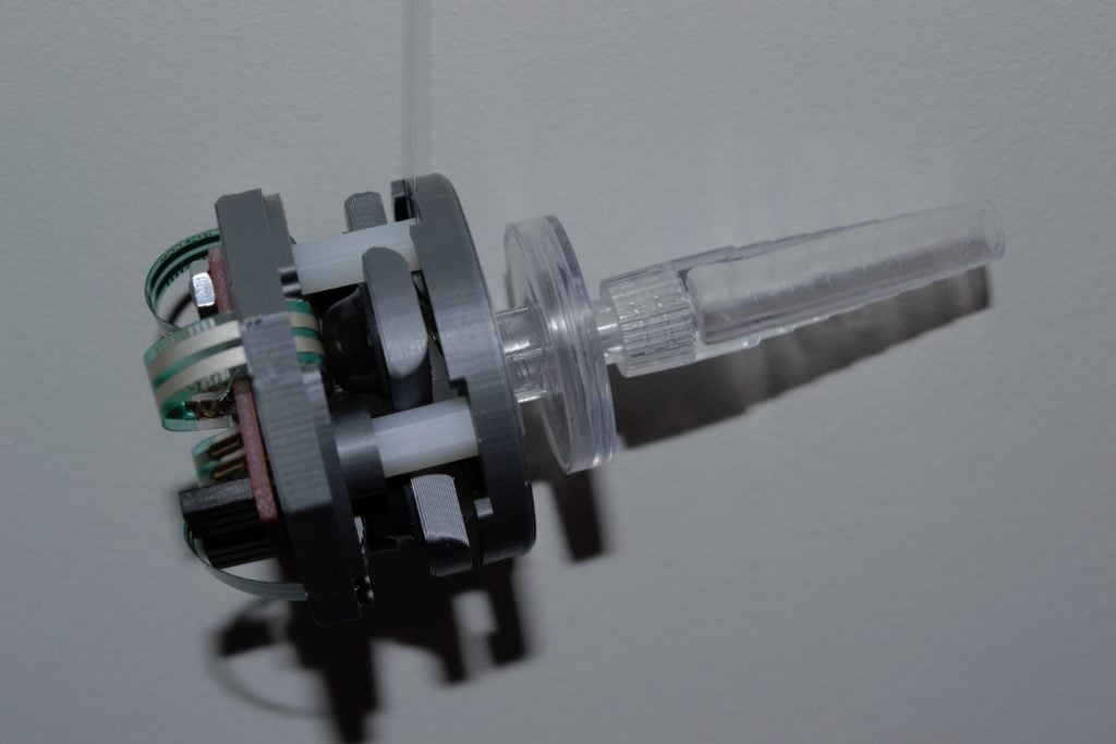 The Lip Sync hardware, including grey casing and a clear sip piece.