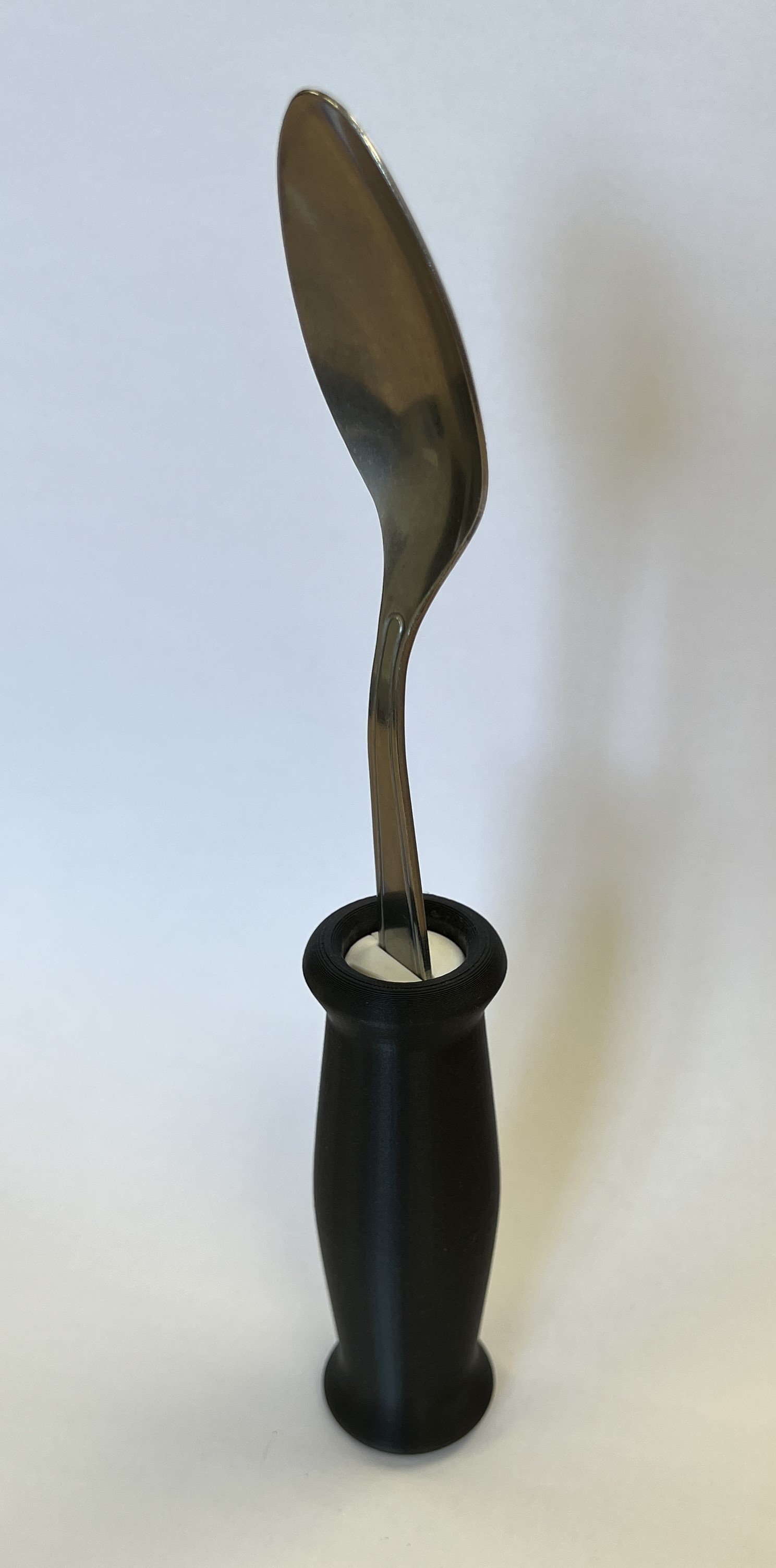 An IKEA spoon within a rounded grip 3D printed handle.