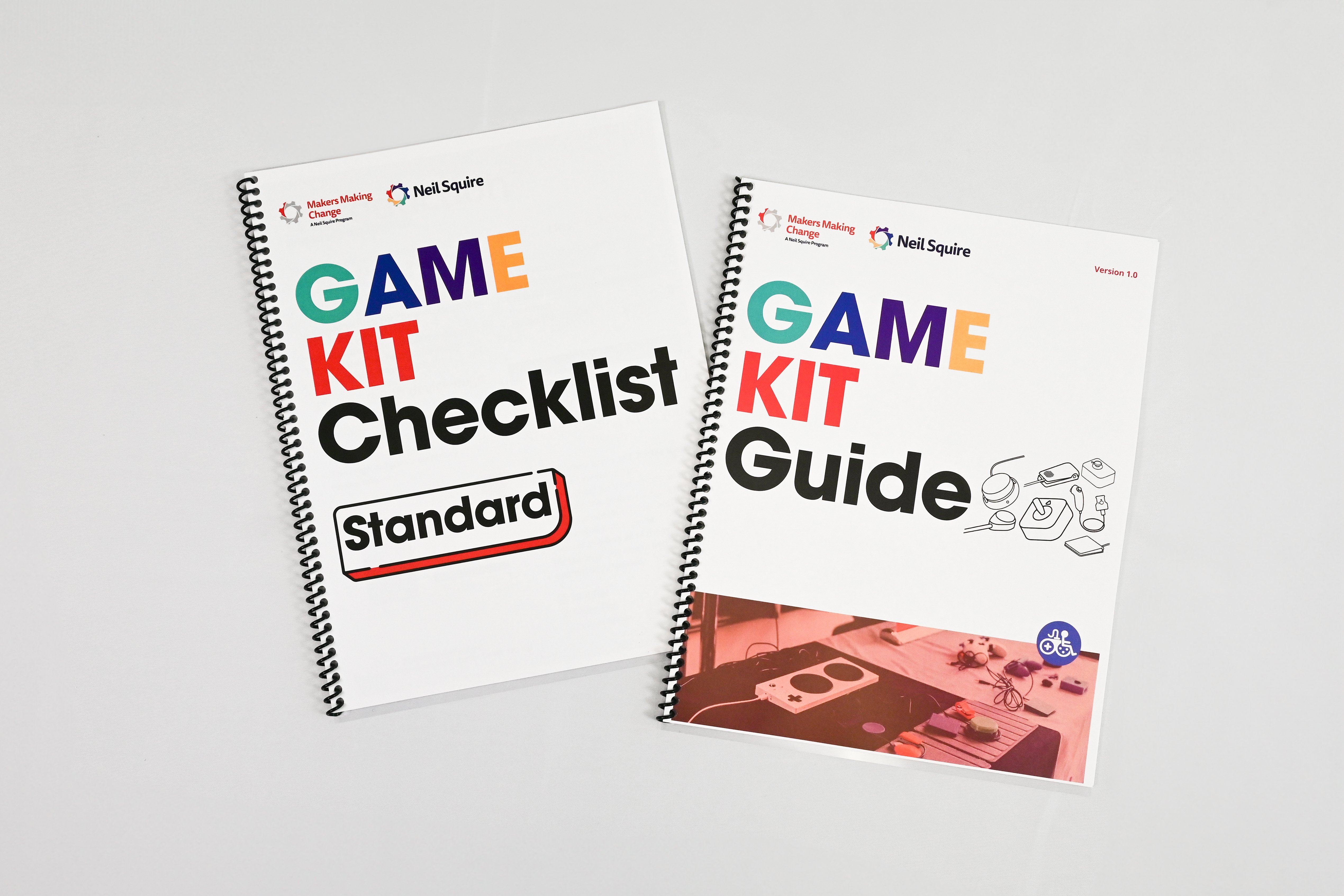 Image of two booklets laying out on a table. One says "GAME KIT Checklist Standard" and one says "GAME KIT Guide". Various branding is on the booklet as well.