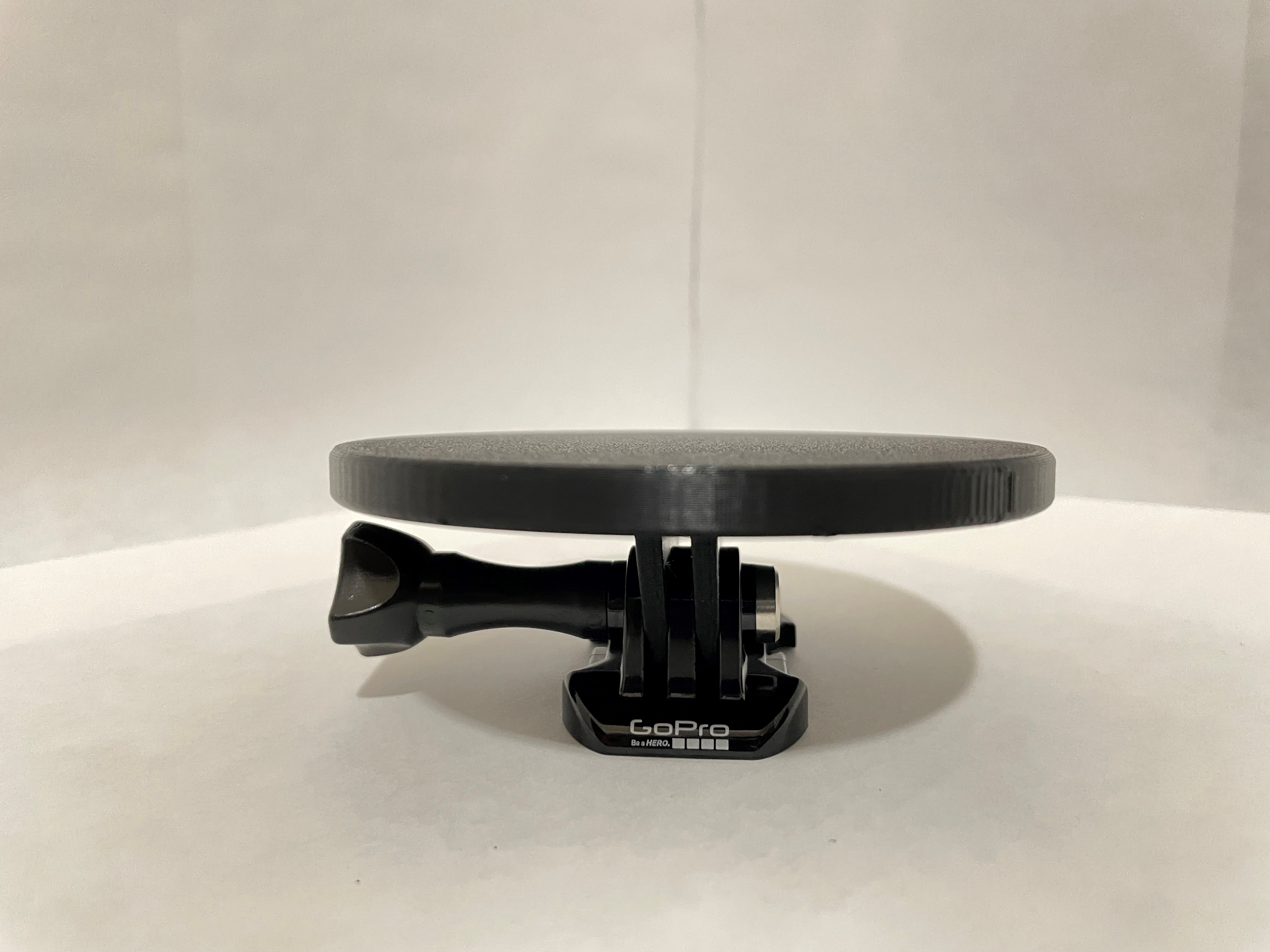 A black Switch Plate assembled with a GoPro mounting accessory.