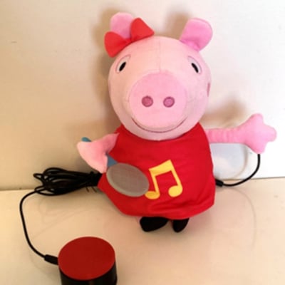 An interact switch plugged into a plush toy shaped as Peppa Pig