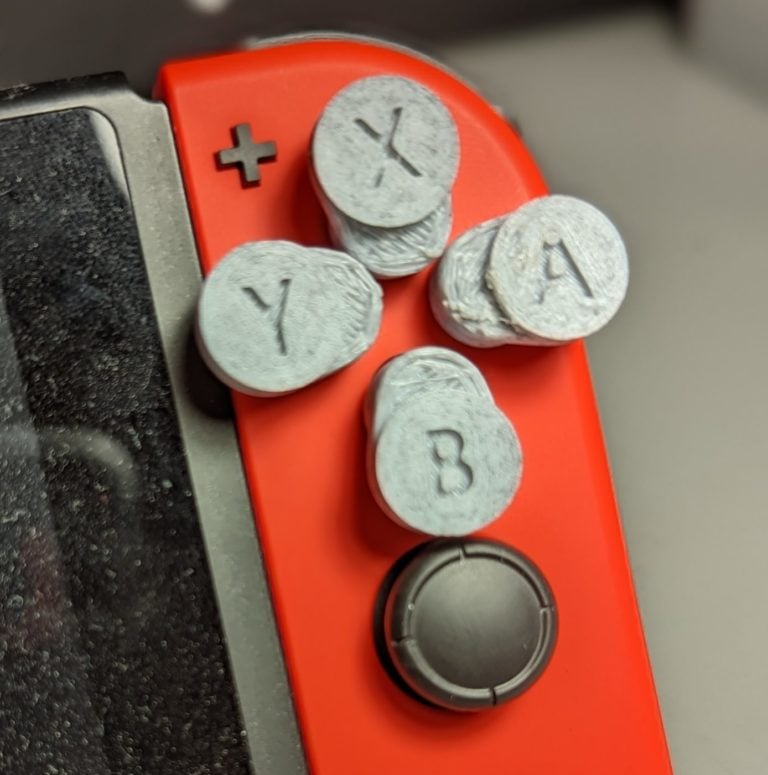Grey A, B, X, Y buttons on a red switch.