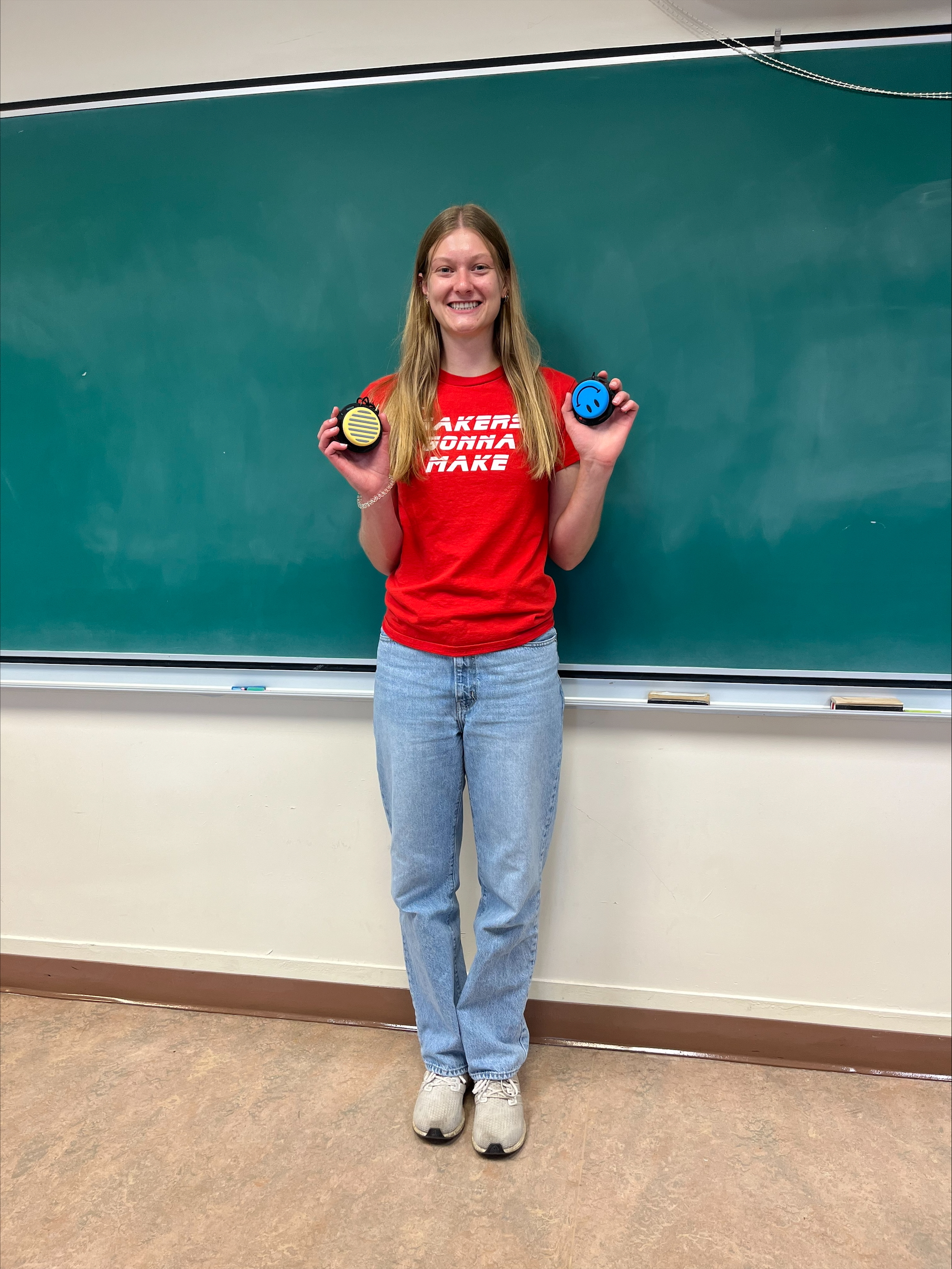 Co-op STEM Event Leader Grace in a classroom holding two switches.