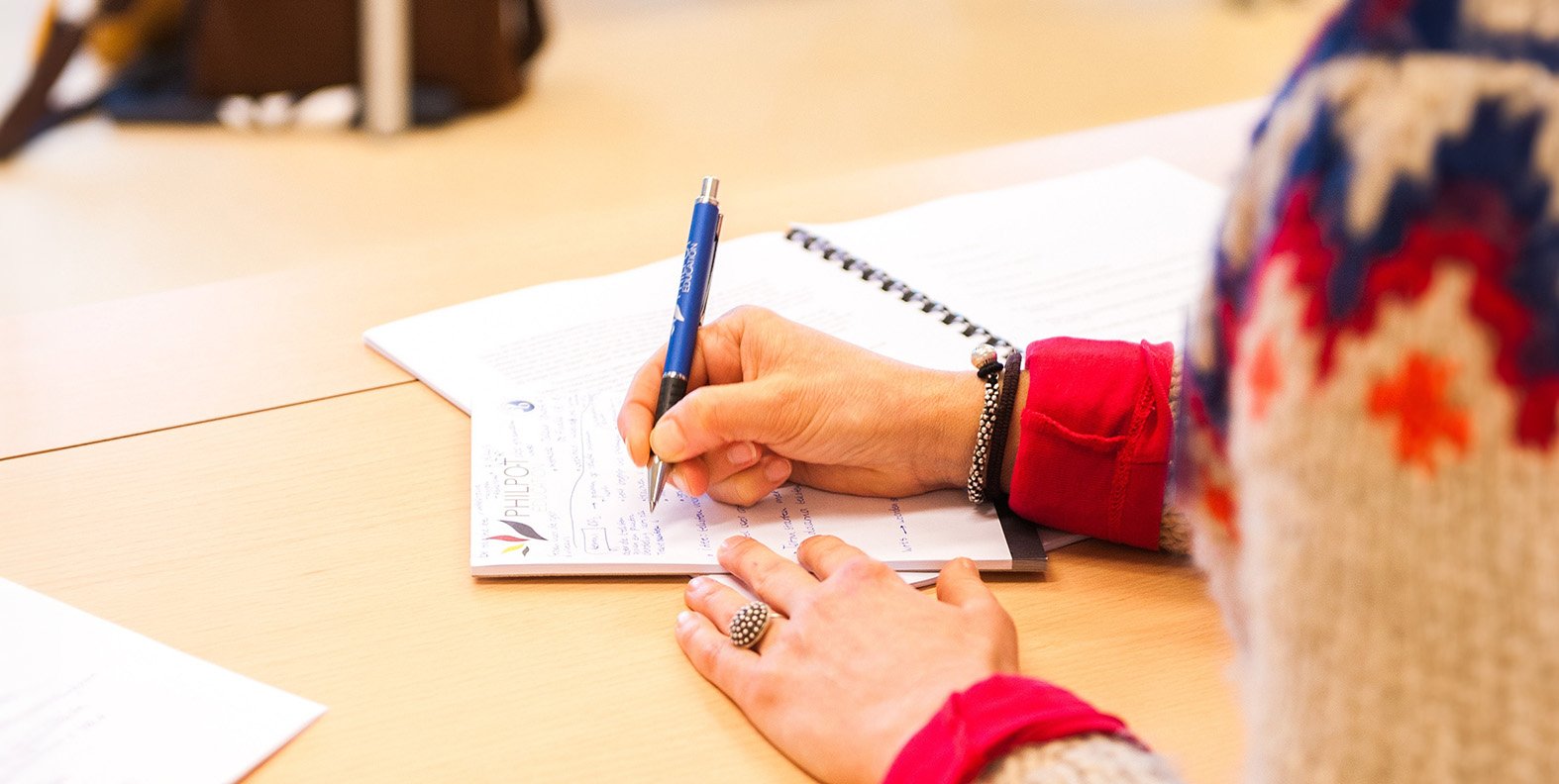 A teacher writing notes on a piece of paper.