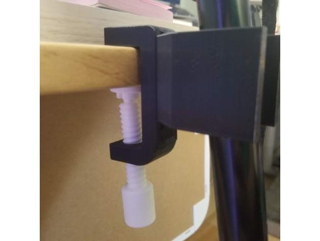 A 3d printed c-clamp mount attached to a wooden table.