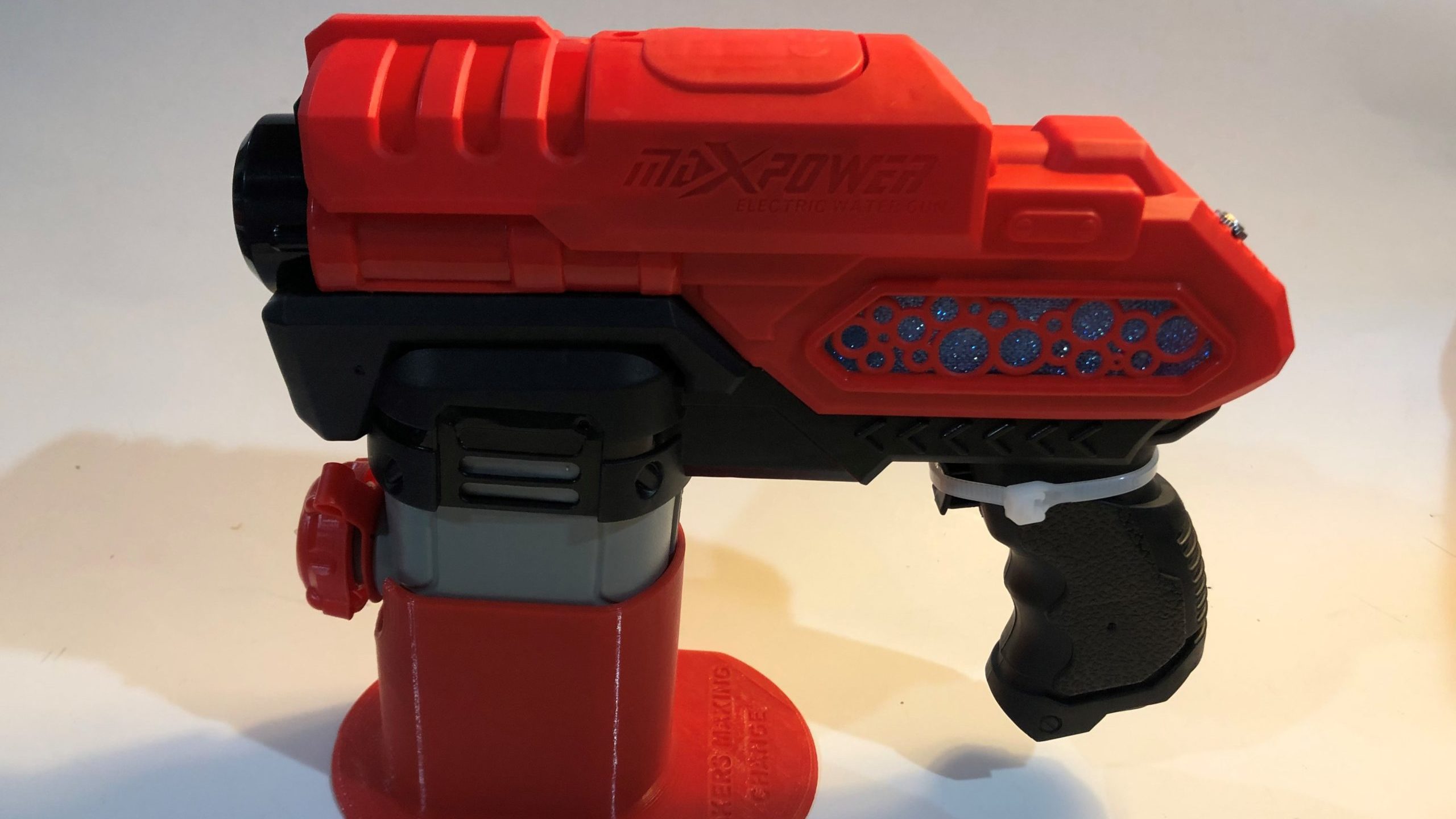 A red and black switch adaptd water gun against a white background.