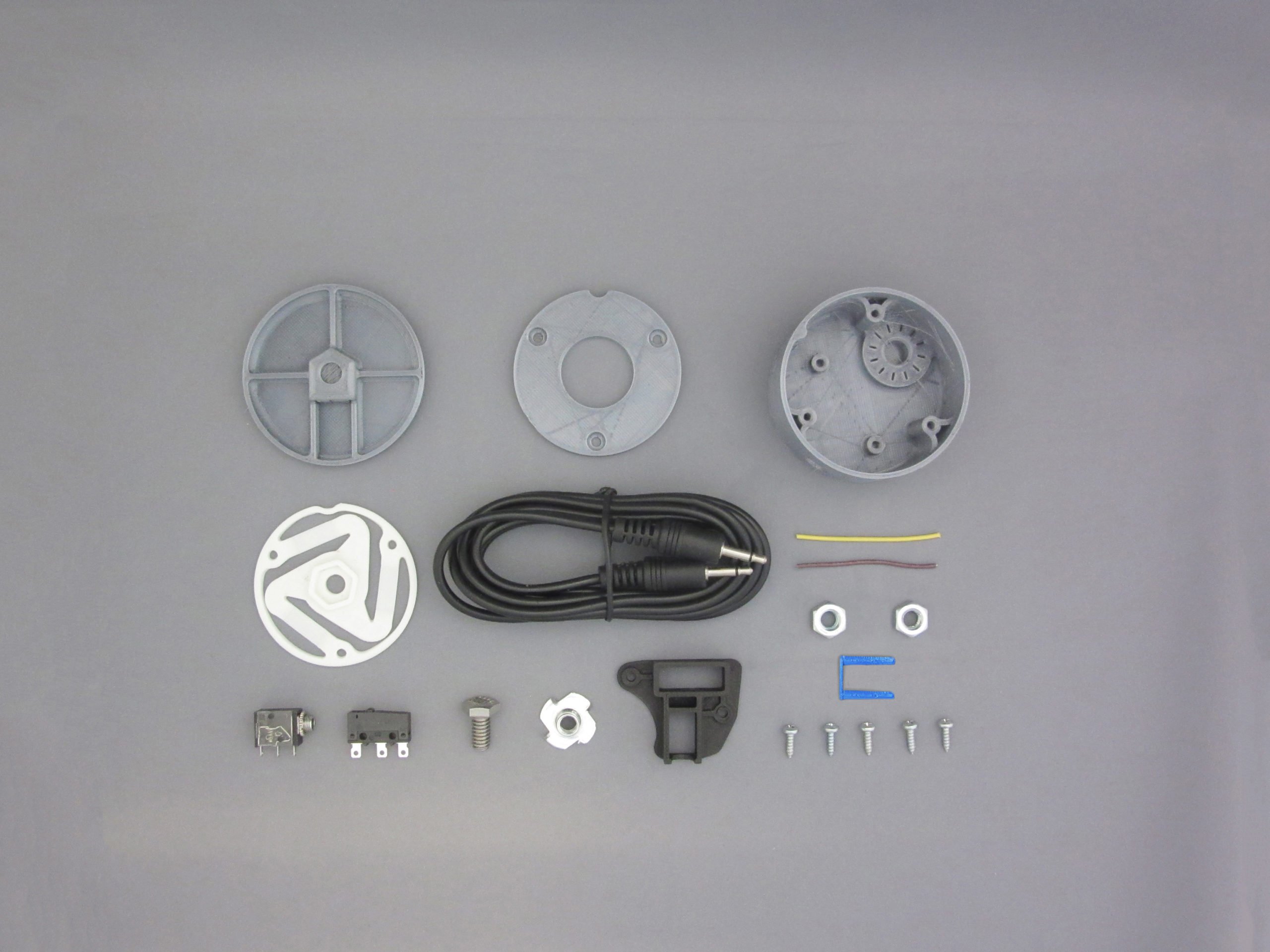 Various 3D printed and electronic components on a grey backgroudn