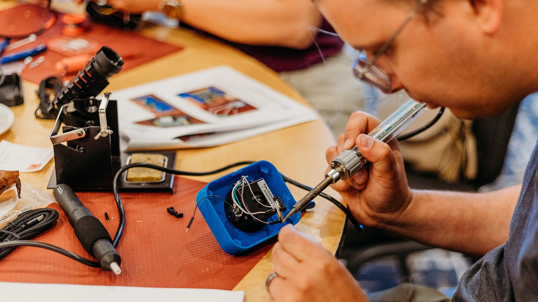 A maker following printed instructioned to build an assistive tech.