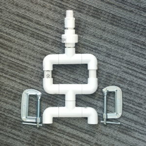 Picture of PVC components and c-clamps that make up PAMS PVC LipSync desk mount