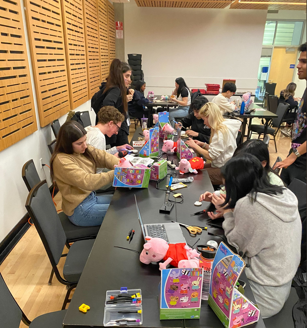 A room of volunteers adapting peppa pig toys.