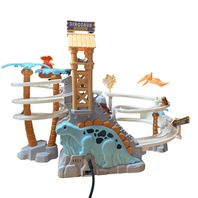 An assistive switch plugged into a large, plastic toy dinosaur. There are two small dinosaur sliding down a sloped race track that wraps around the large dinosaur.