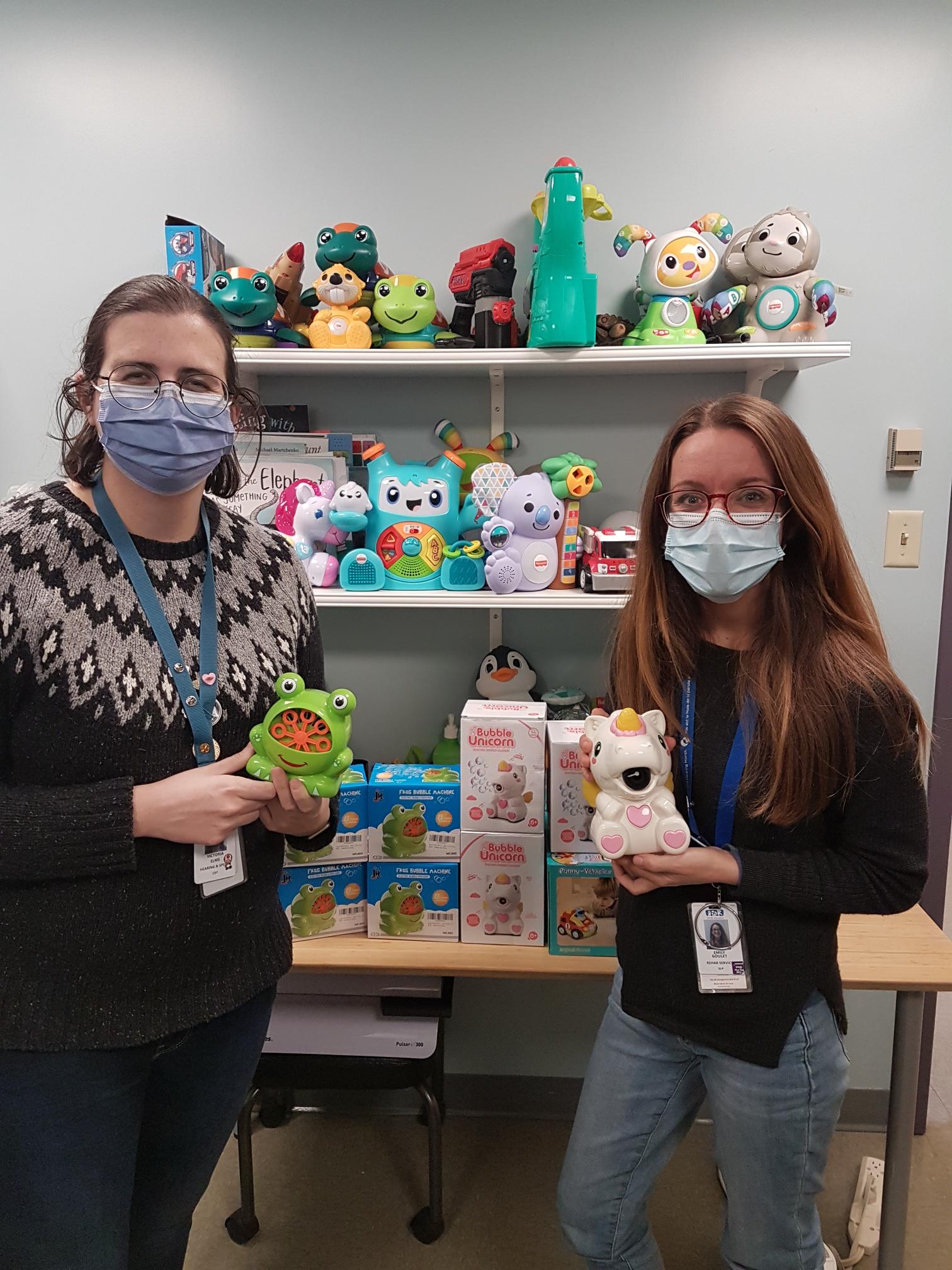 Occupational therapists holding switch-adapted toys.