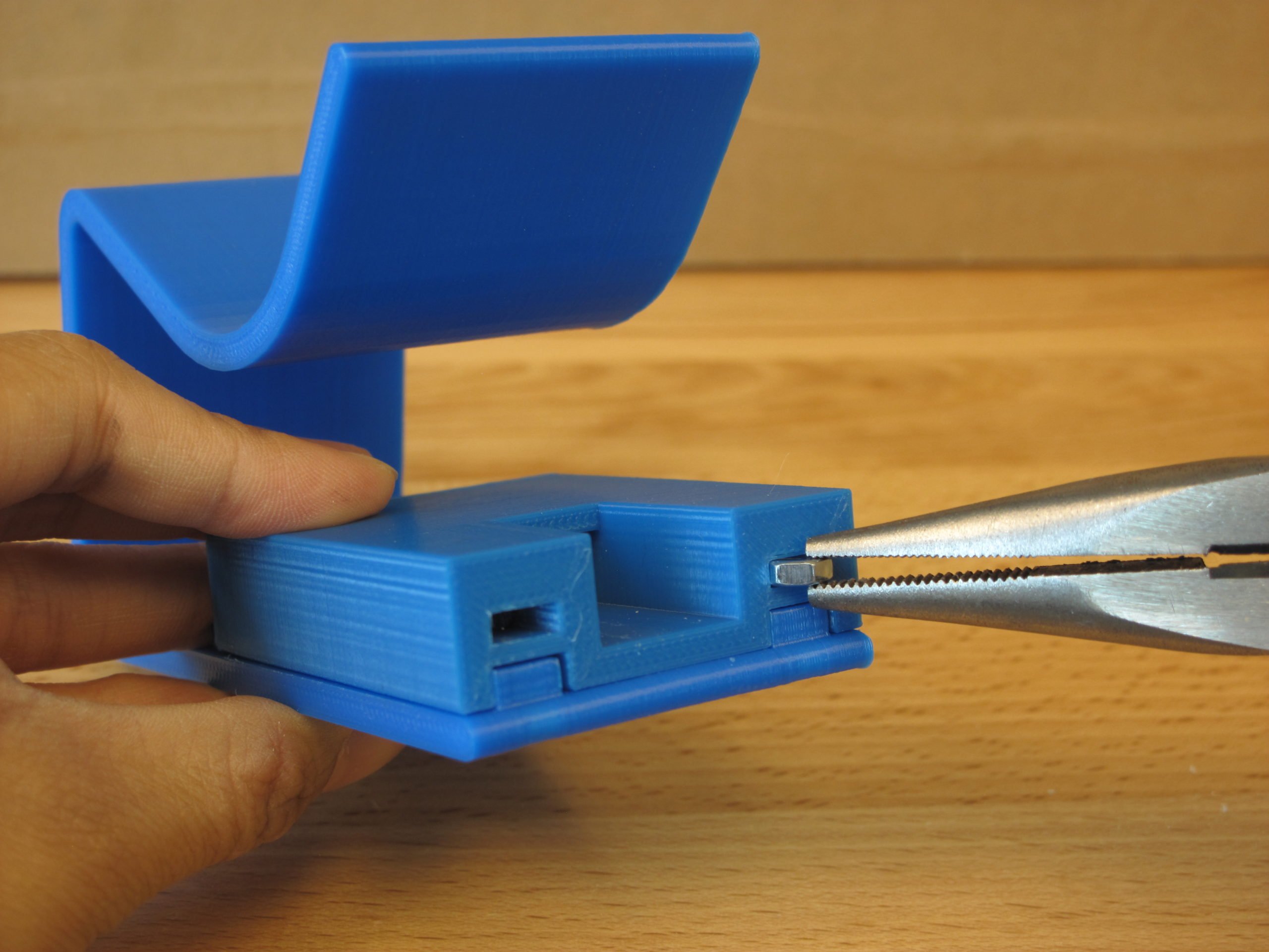 A user assembling the 3D Printed Nail Clipper to clip their nails with ease