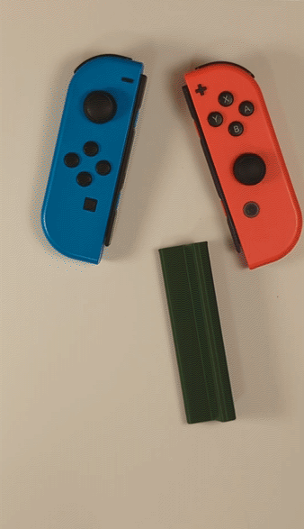 Assembly gif showing two Nintendo Switch joy-cons slotting into a green 3D printed adapter.