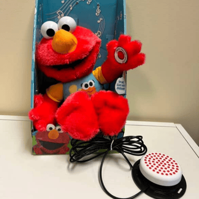 Red Elmo plush toy with a switch plugged in.