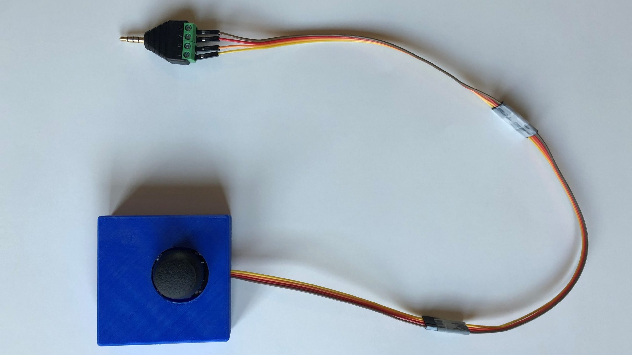 A blue 3d printed analog thumbstick with a jack coming out of one end.
