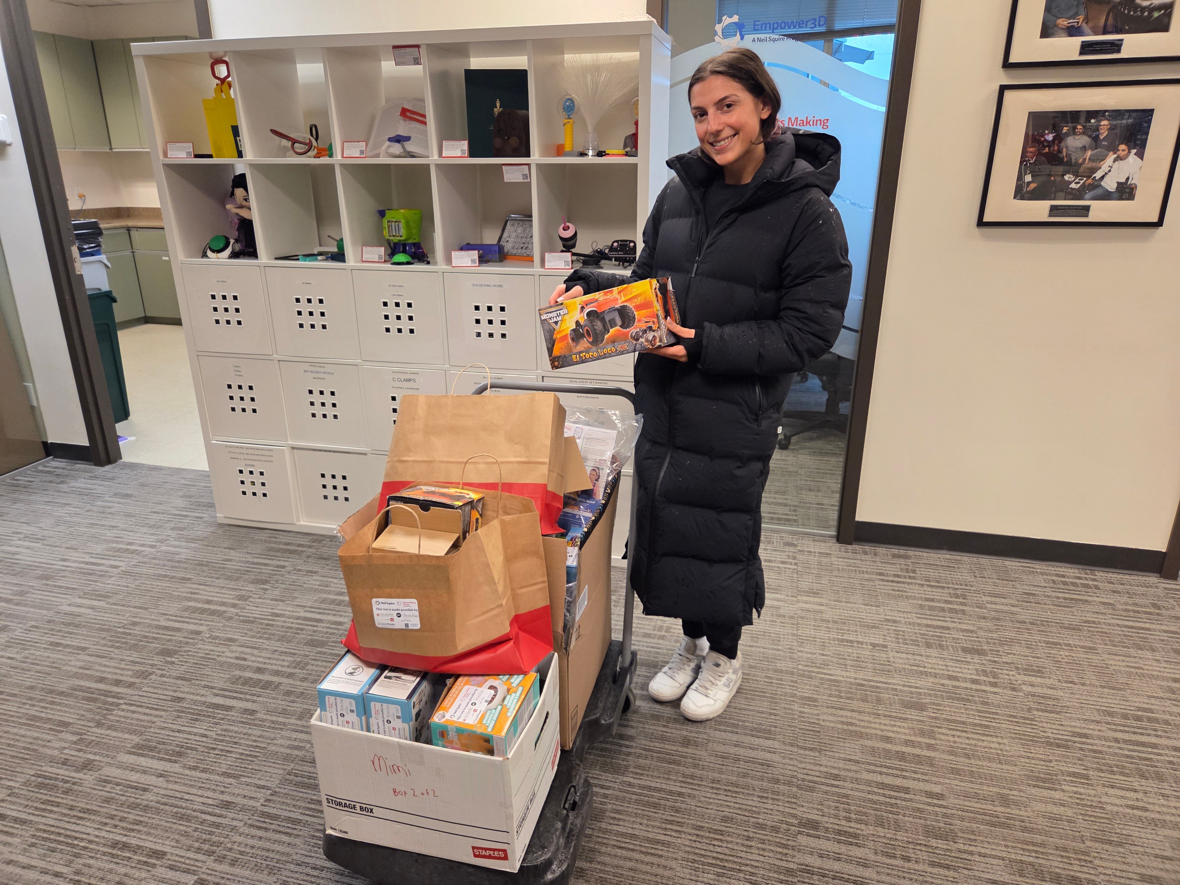 An occupational therapist picking up a trolley of adapted toys.