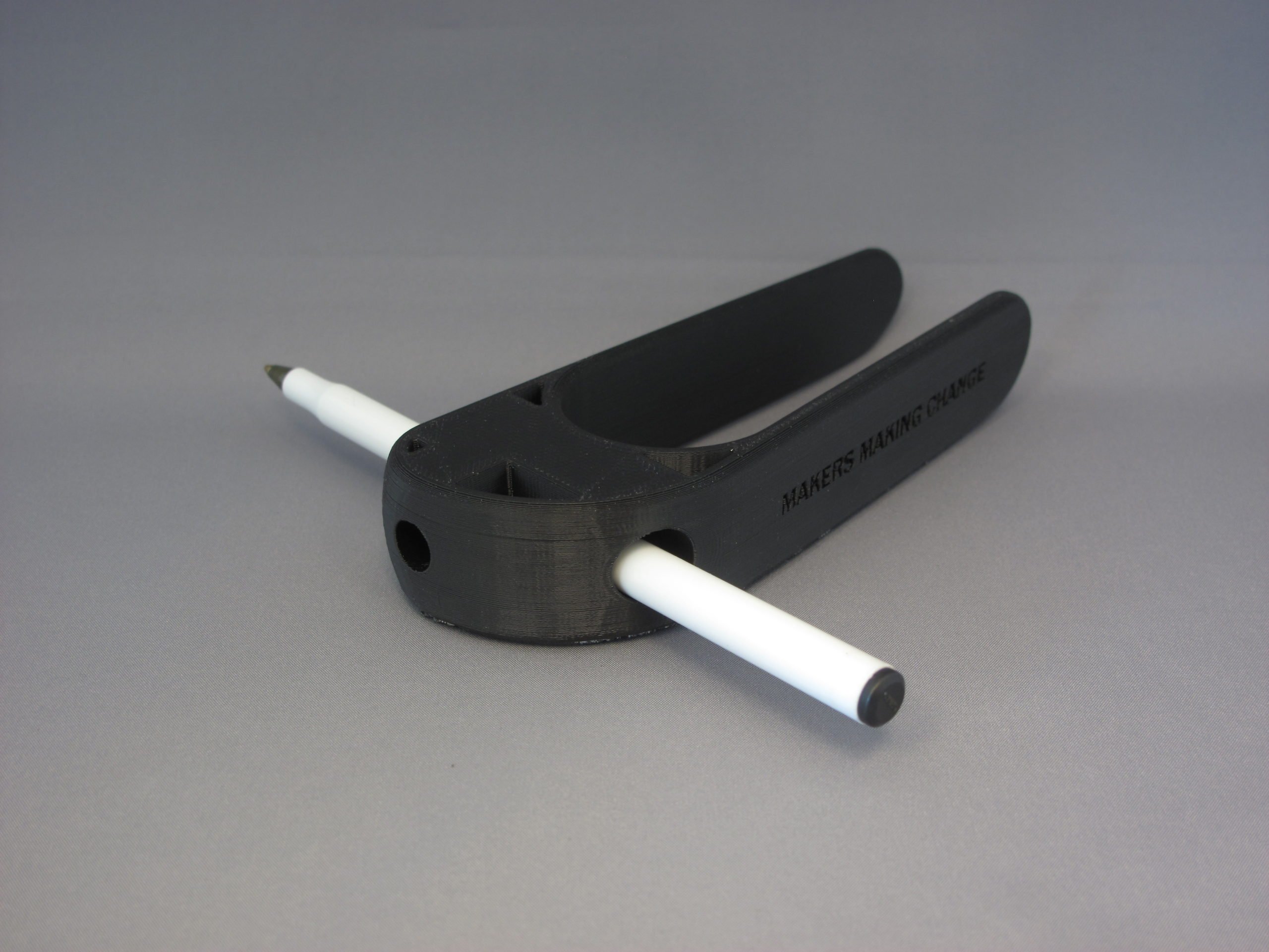 A user using the 3D Printed Palm Pen Holder to draw on a piece of paper with ease