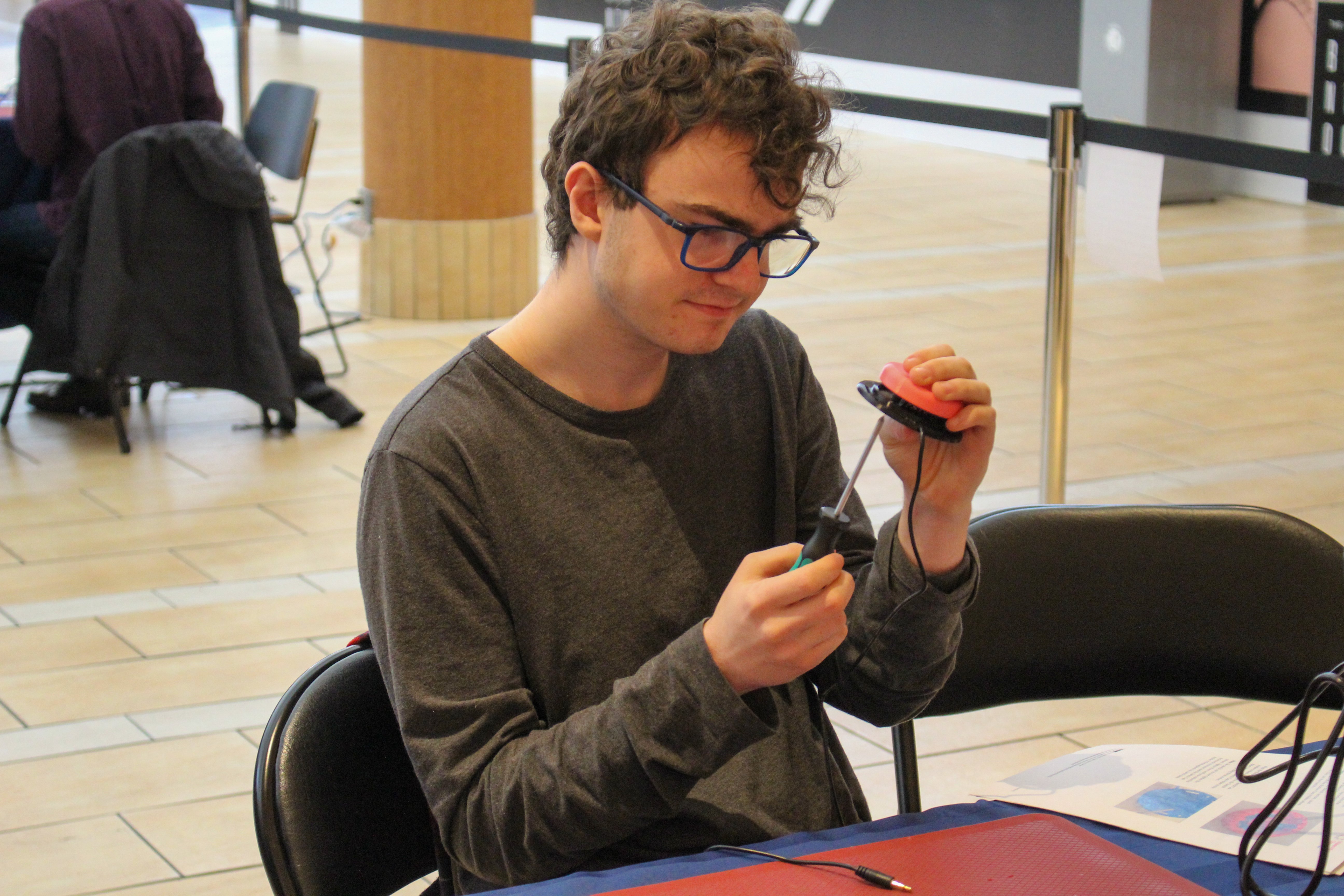 Jaxon uses a screwdriver to work on an Interact Switch.