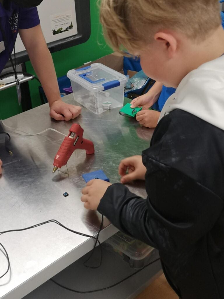A volunteer maker examining electronics.