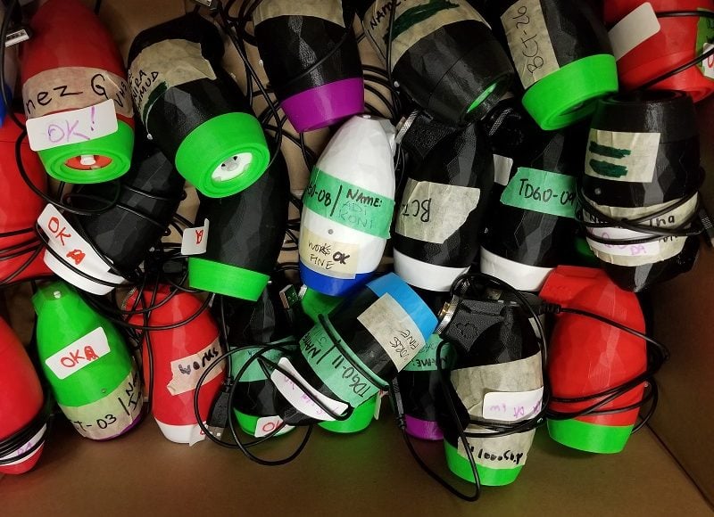 A box of assorted LipSync devices in different colours.