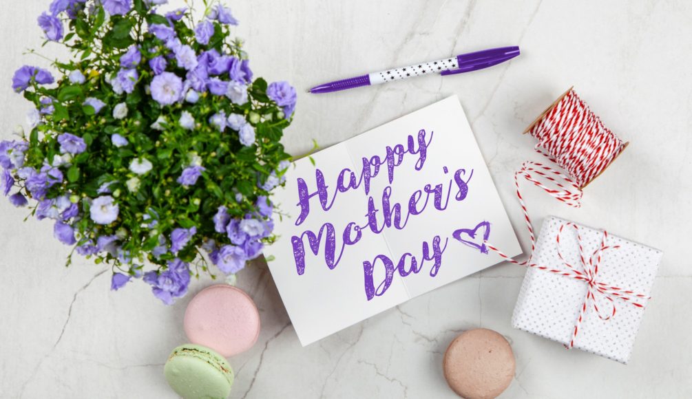 A purple plant and a card beside it that says "Happy Mother's Day."