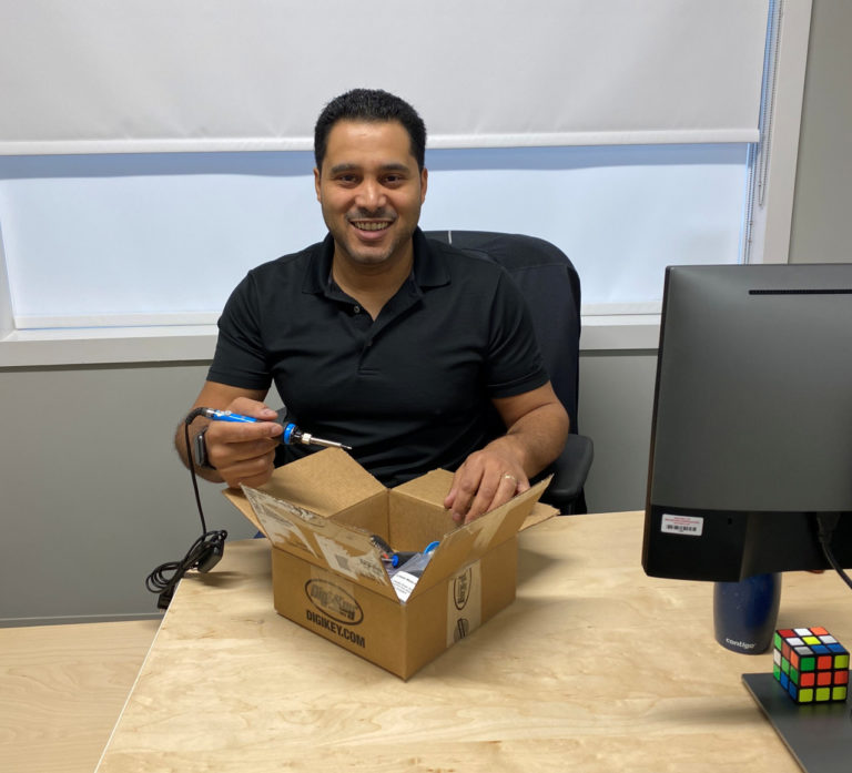 Dan from Neovation pictured smiling and holding a soldering iron.