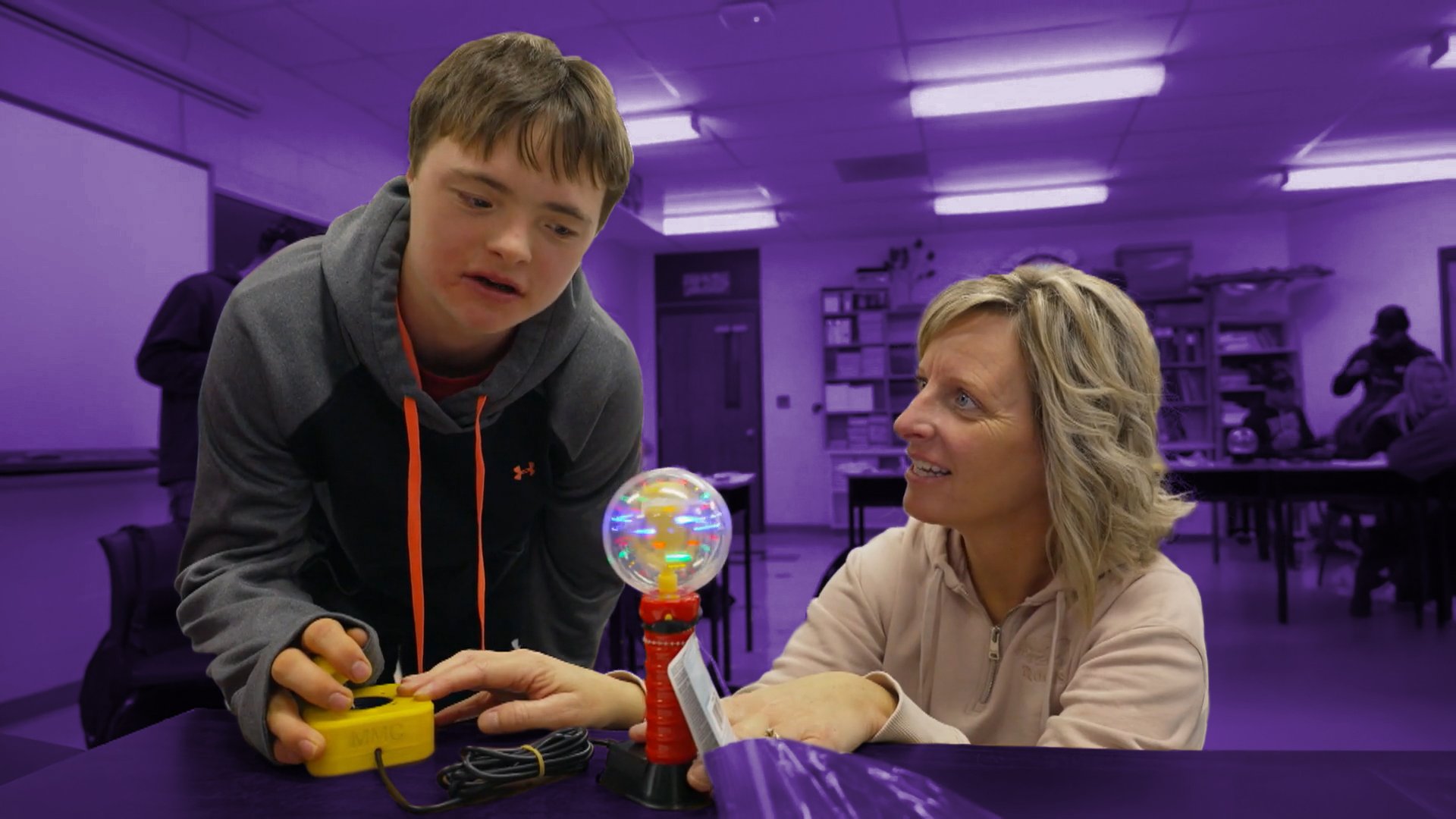 A boy pressing a switch to activate a light wand toy.