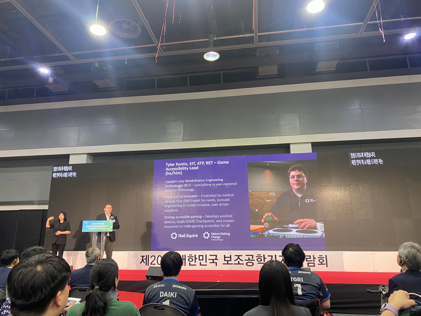 Tyler presenting on stage at the International Symposium on Assistive Technology.