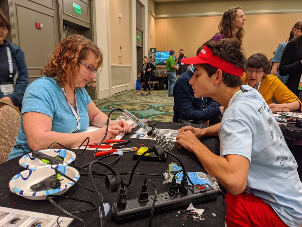Two volunteers making an assistive device.