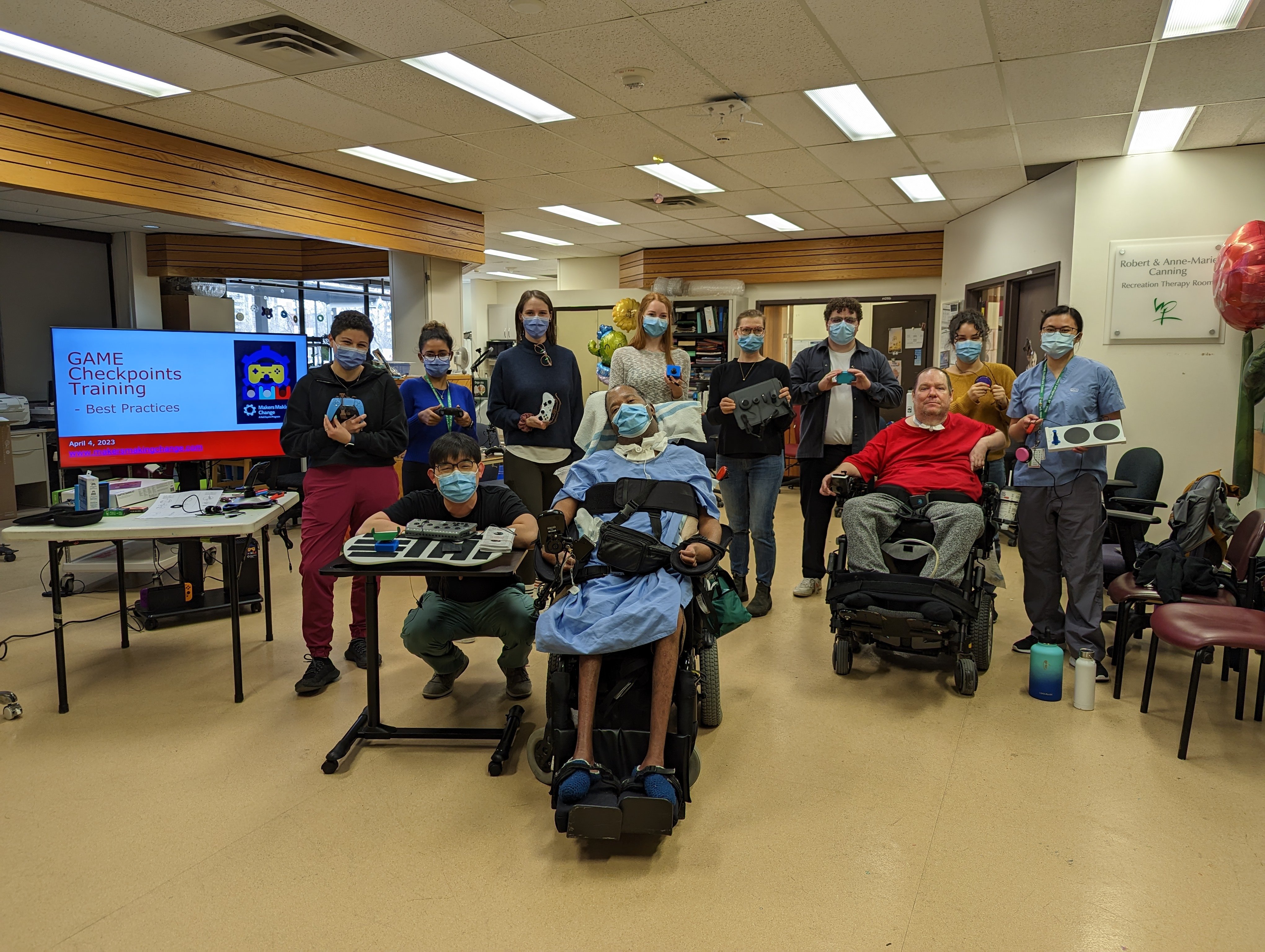 West Park staff, patients, and MMC staff pose together with the adaptive gaming equipment at West Park.