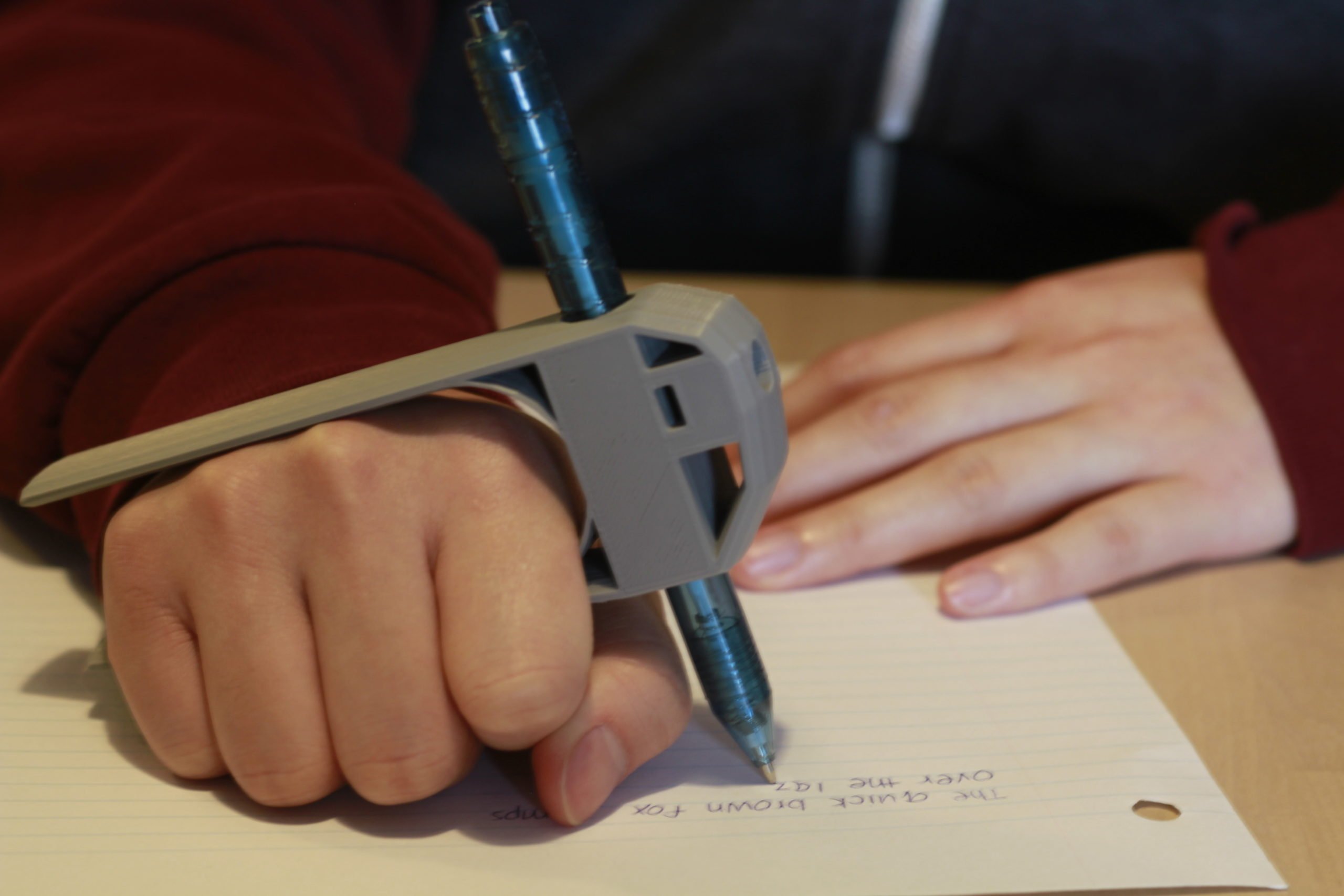 Close up of individual using the palm pen to write on paper