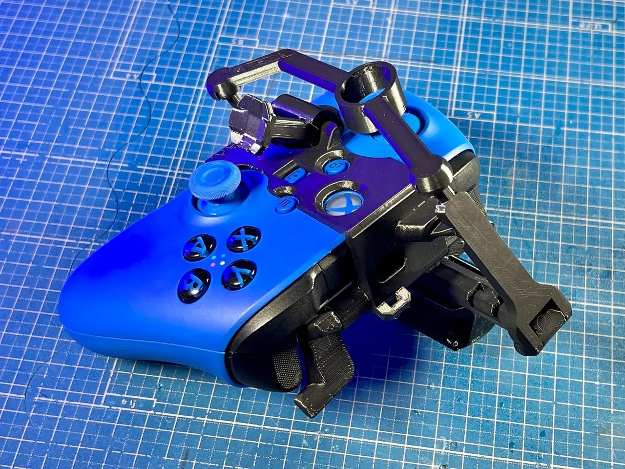 Back view of a one-handed controller modification on an Xbox Series X|S Controller. This controller modification is 3D printed in black and blue and is the right-handed variation.