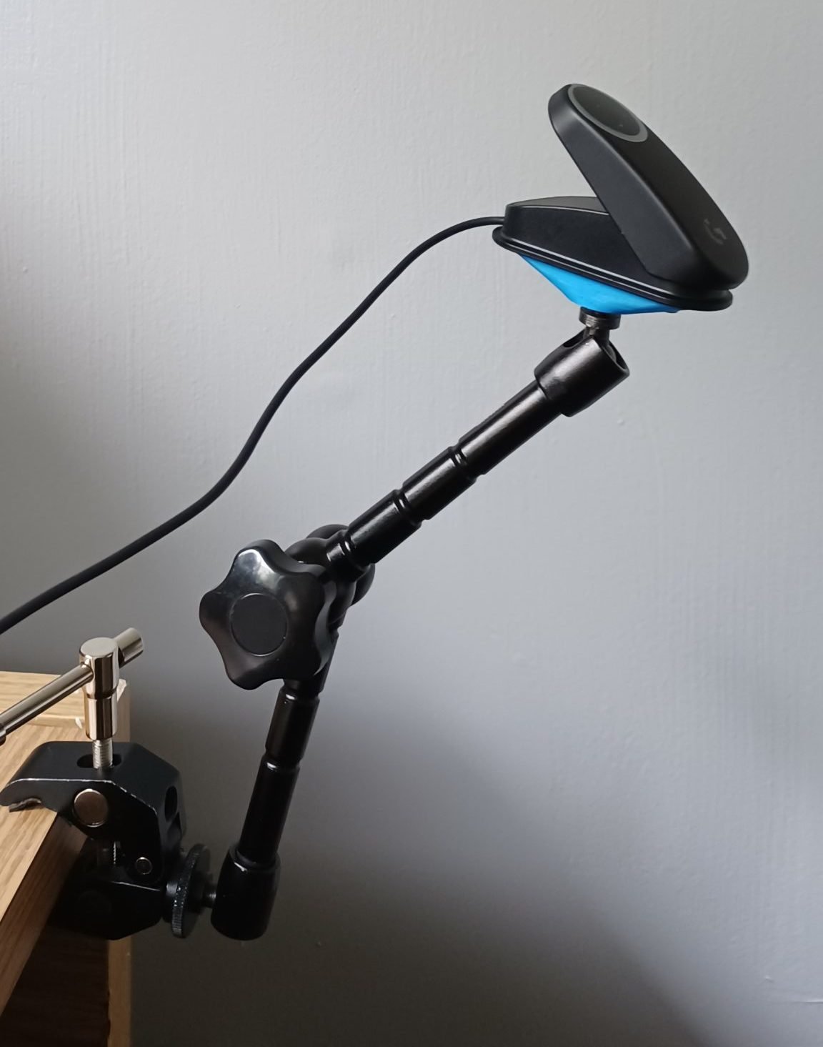 A blue 3d printed mounting base attached to a black logitech variable trigger button.