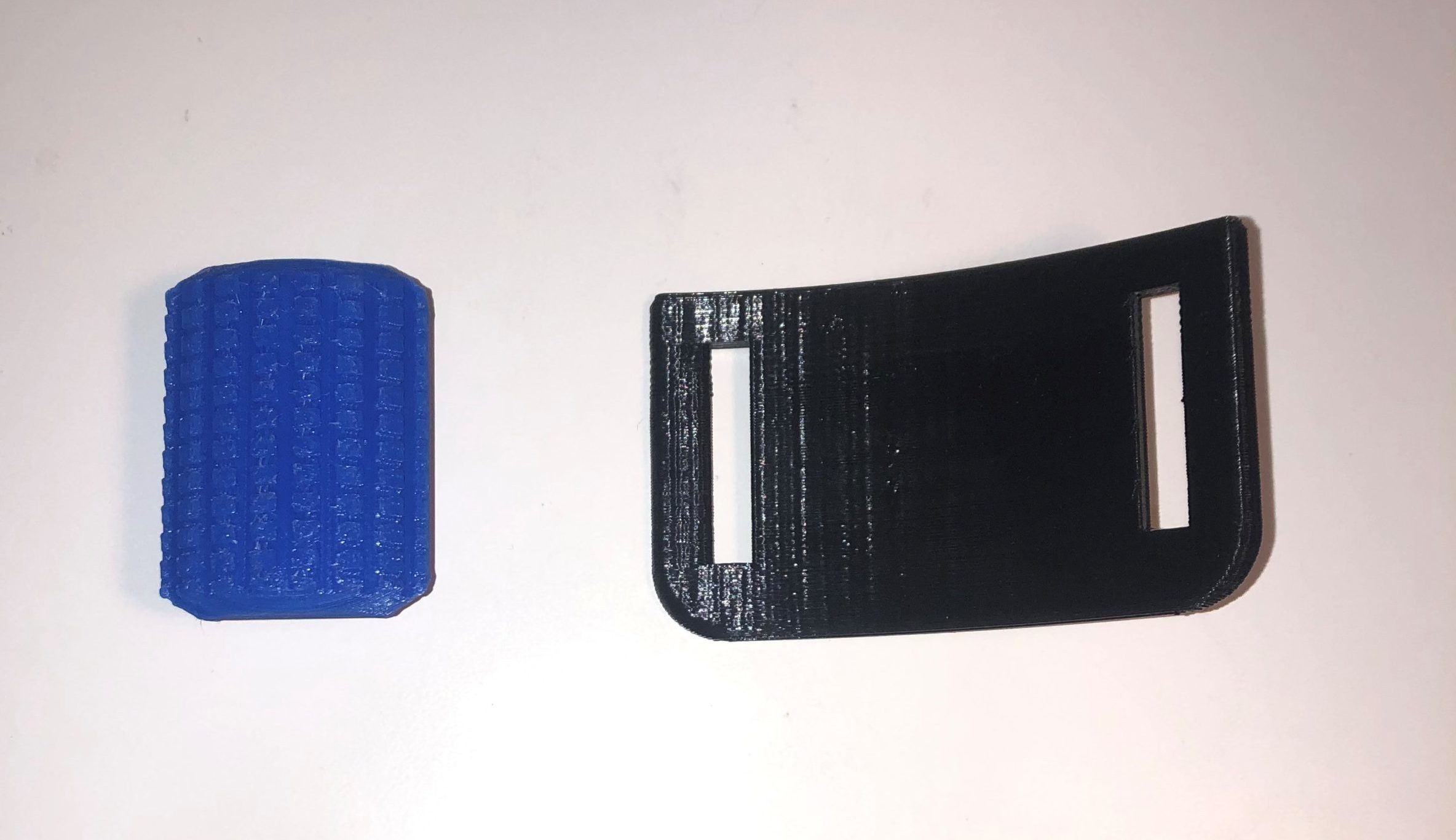Blue and black 3d printed parts shaped in an arc against a white background.