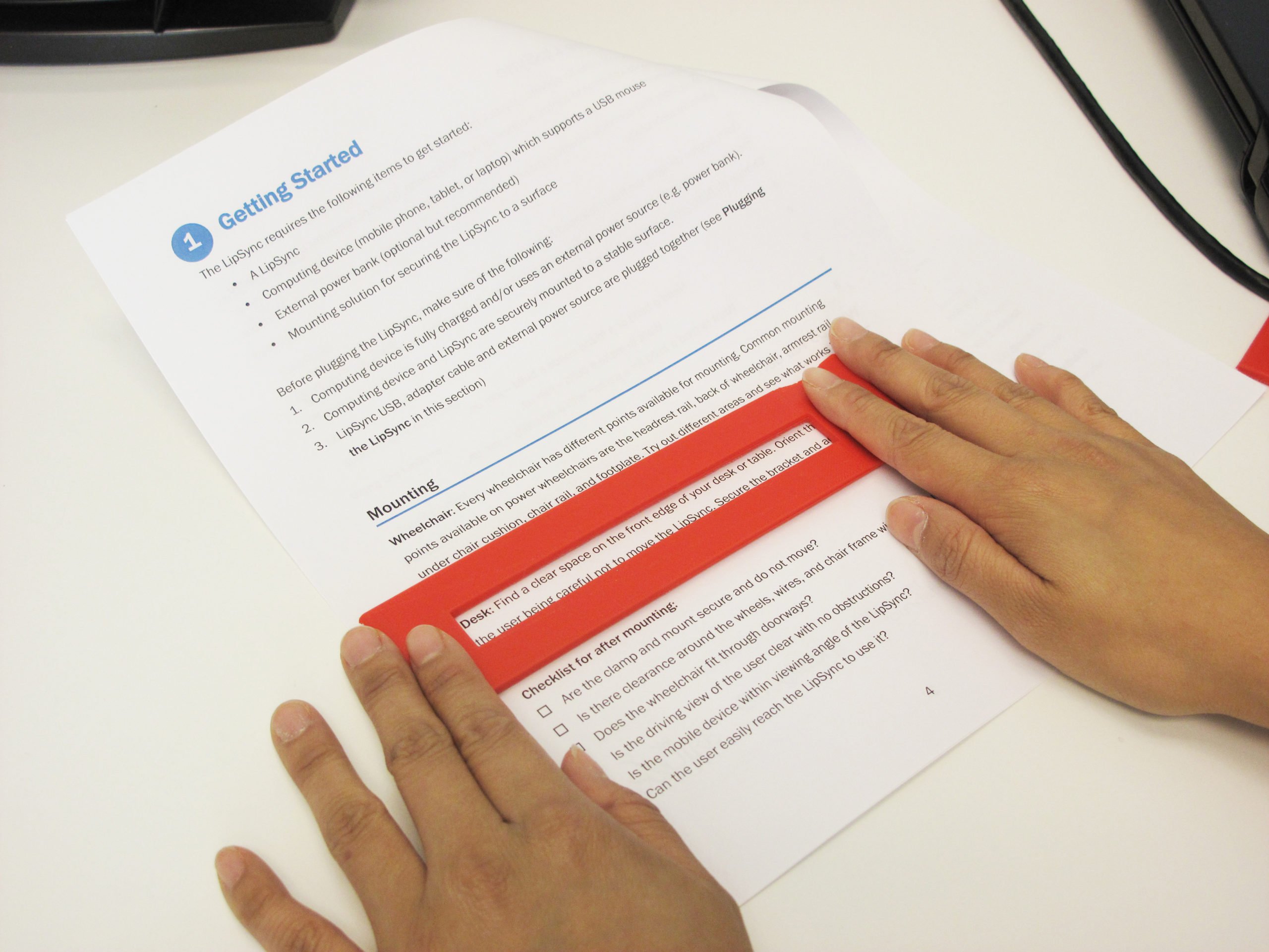 A user with dyslexia using the Flat Reading Bar to read the paper with ease