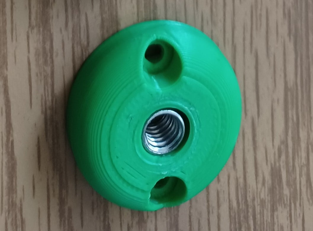 Green 3d printed small button with a t-nut inserted.