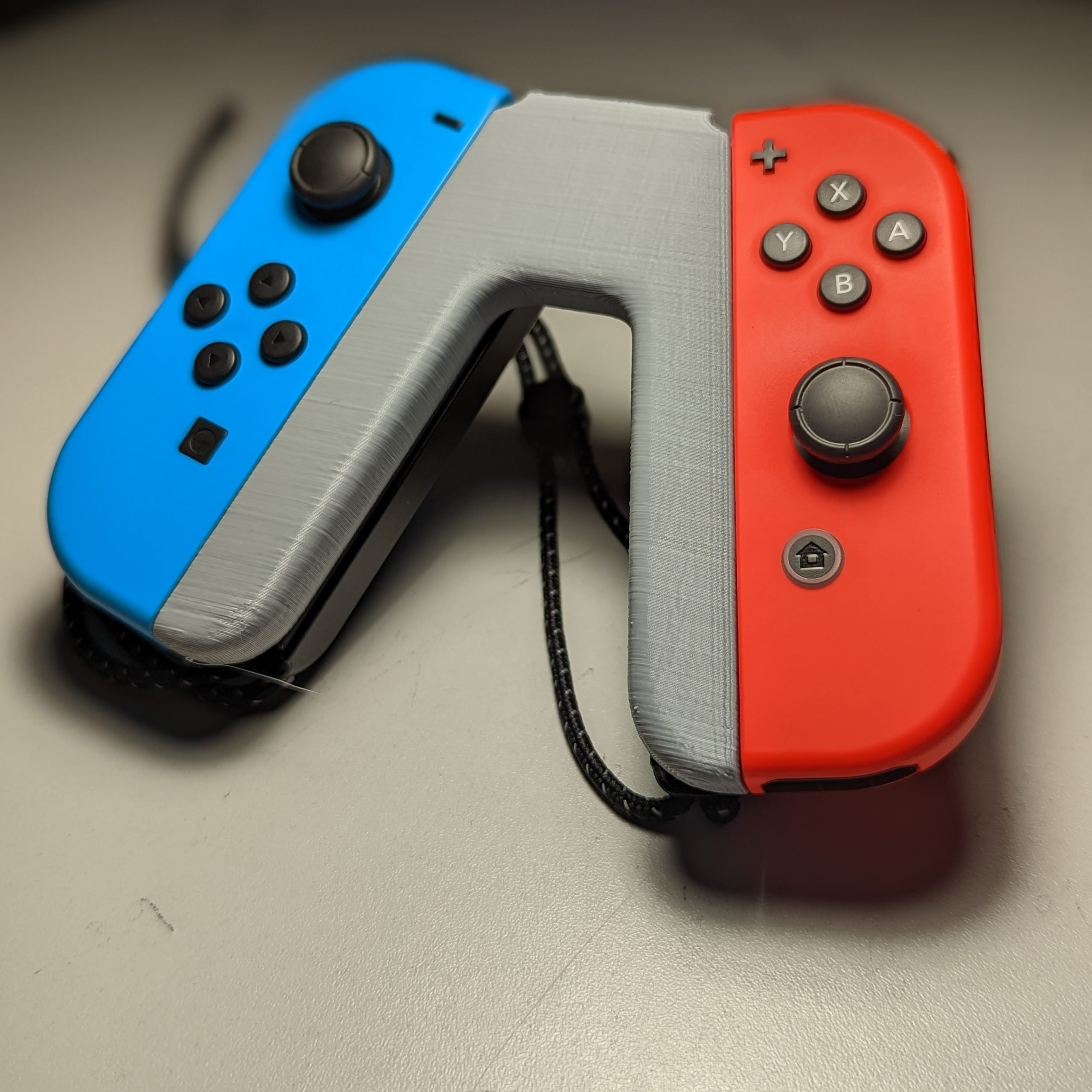 A grey 3d printed joy-con grip with red and blue nintendo switch controllers attached.