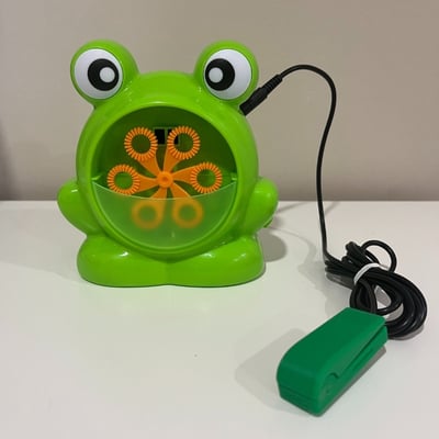 A raindrop switch plugged into a bubble machine shaped as a frog with big eyes