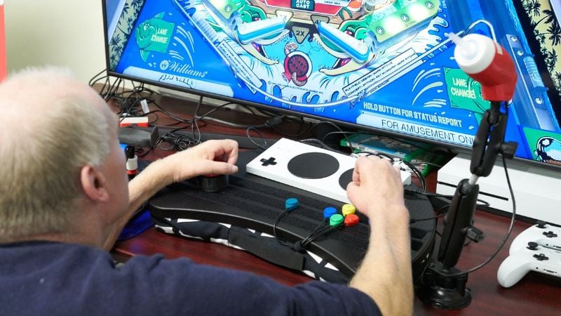 Individual using adaptive devices to play video games.
